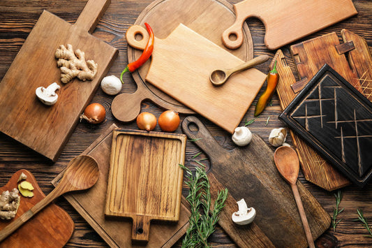 Several kinds of cutting boards spread out on table with fresh produce 
