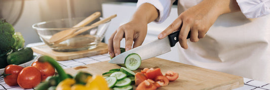 home cook slicing vegetables with sharp chef knife on wooden cutting board, natural kitchen lighting, close-up food prep, modern kitchen