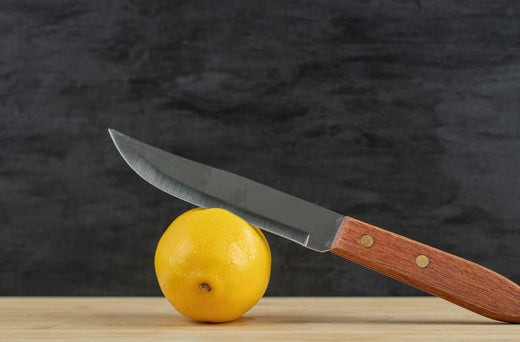 Dull knife laying on lemon
