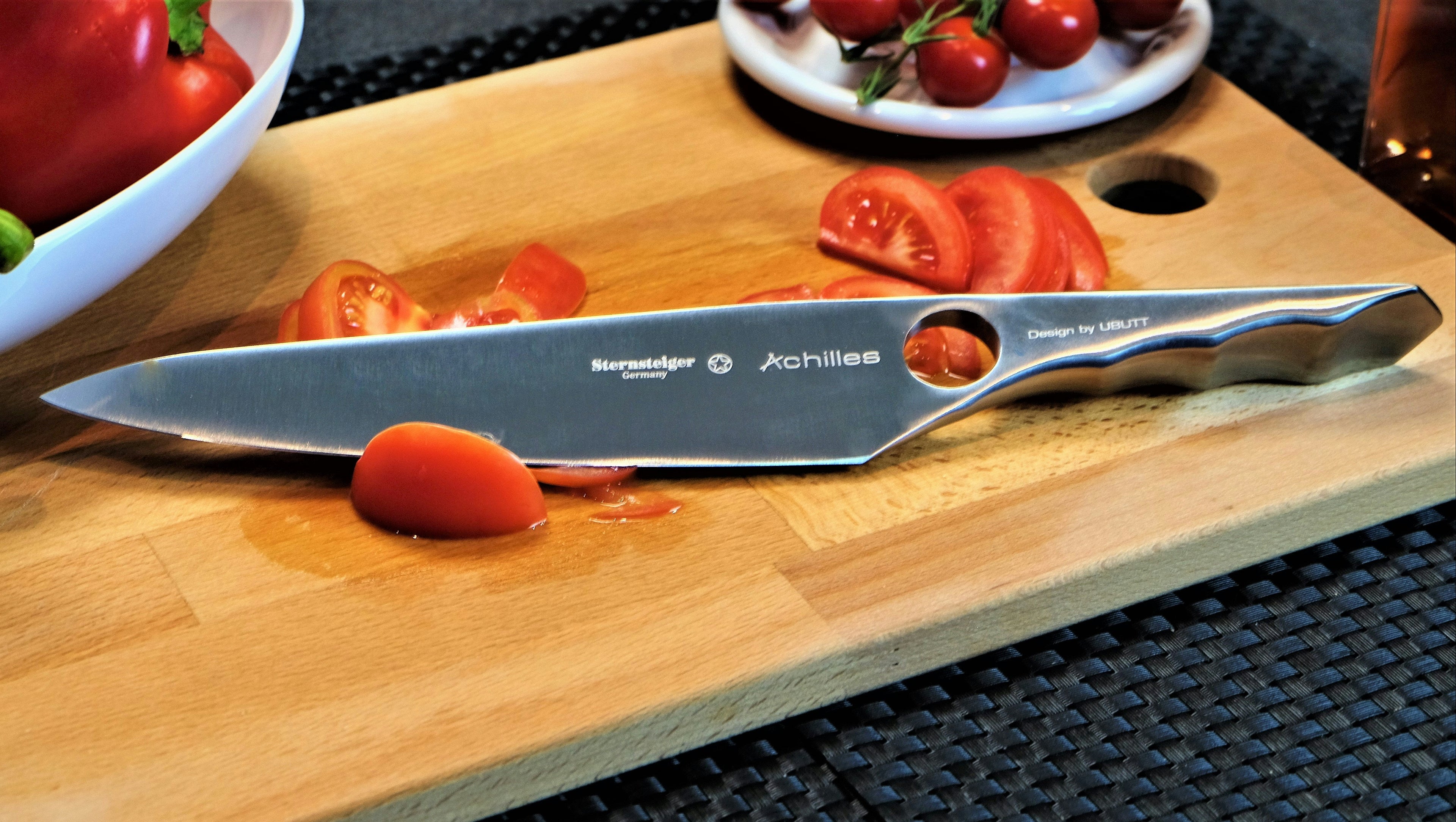 Sternsteiger chef’s knife displayed on a wooden cutting board with fresh tomatoes and colorful peppers, showcasing premium German kitchen knife quality.
